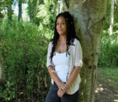 Woman stood and leaning against a tree