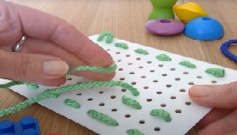 Sewing a card with green thread