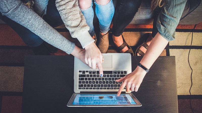 Hands pointing at laptop