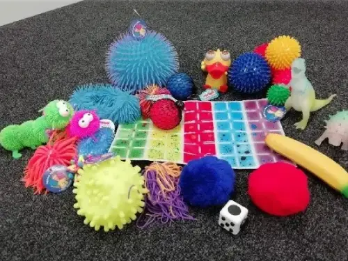 This picture shows a selection of sensory toys on the carpet.