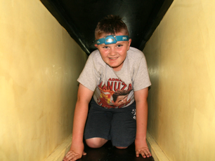 A young boy crawling through tunnels