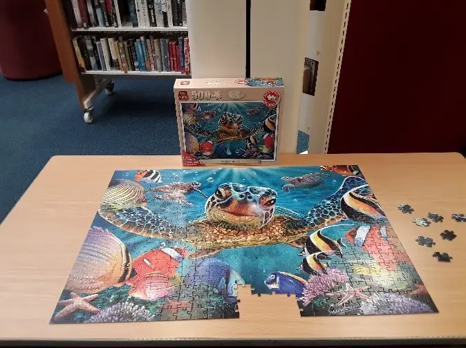 This is a picture of a large nearly completed jigsaw puzzle.  The image on the puzzle is of a turtle.