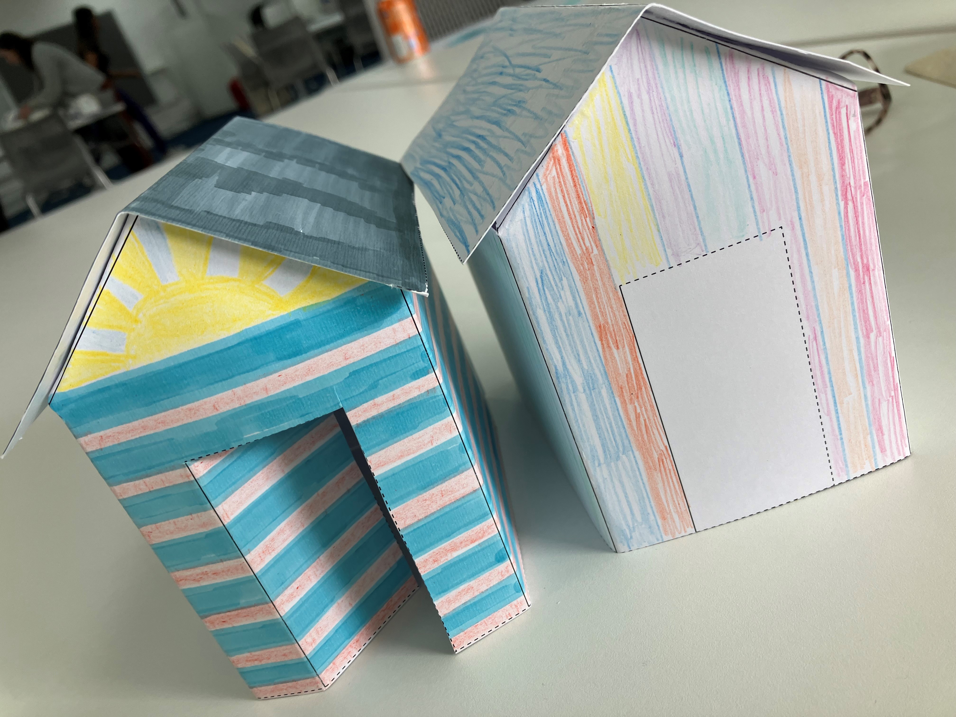two paper houses brightly coloured in