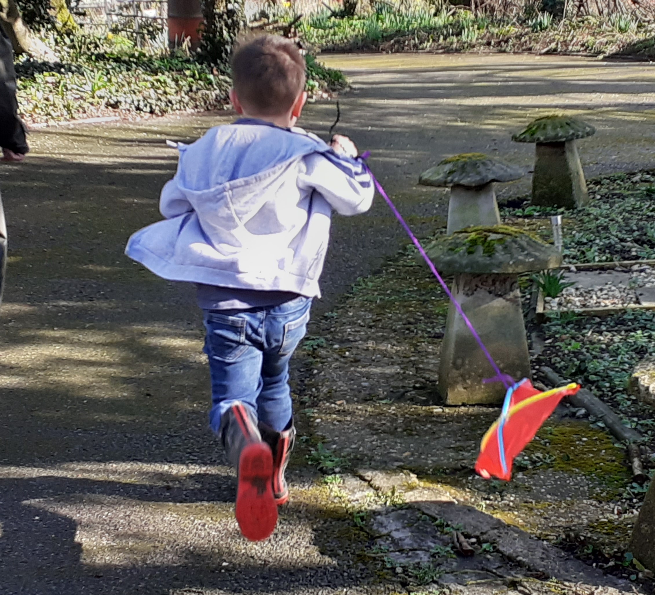 young boy running with a kite