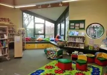 This is a picture of the children's area in the library with floor mat and children's seats.