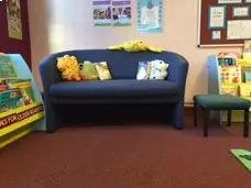 This is a picture of a sofa with cushions on in the children's area.