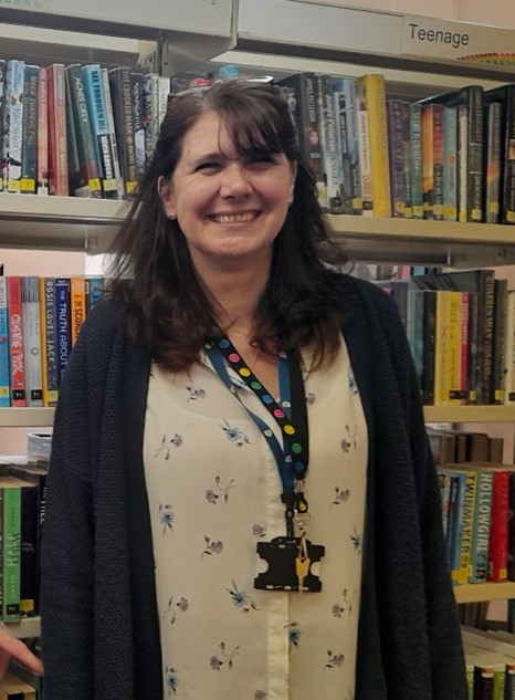 This is a picture of a library assistant smiling at the camera.