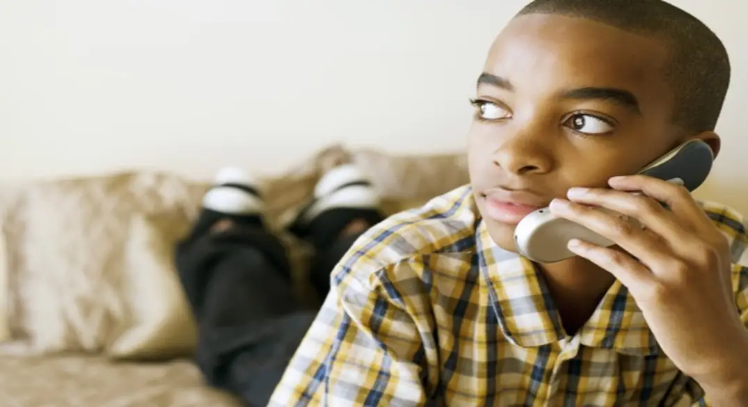 This is a picture of a child talking on the telephone.