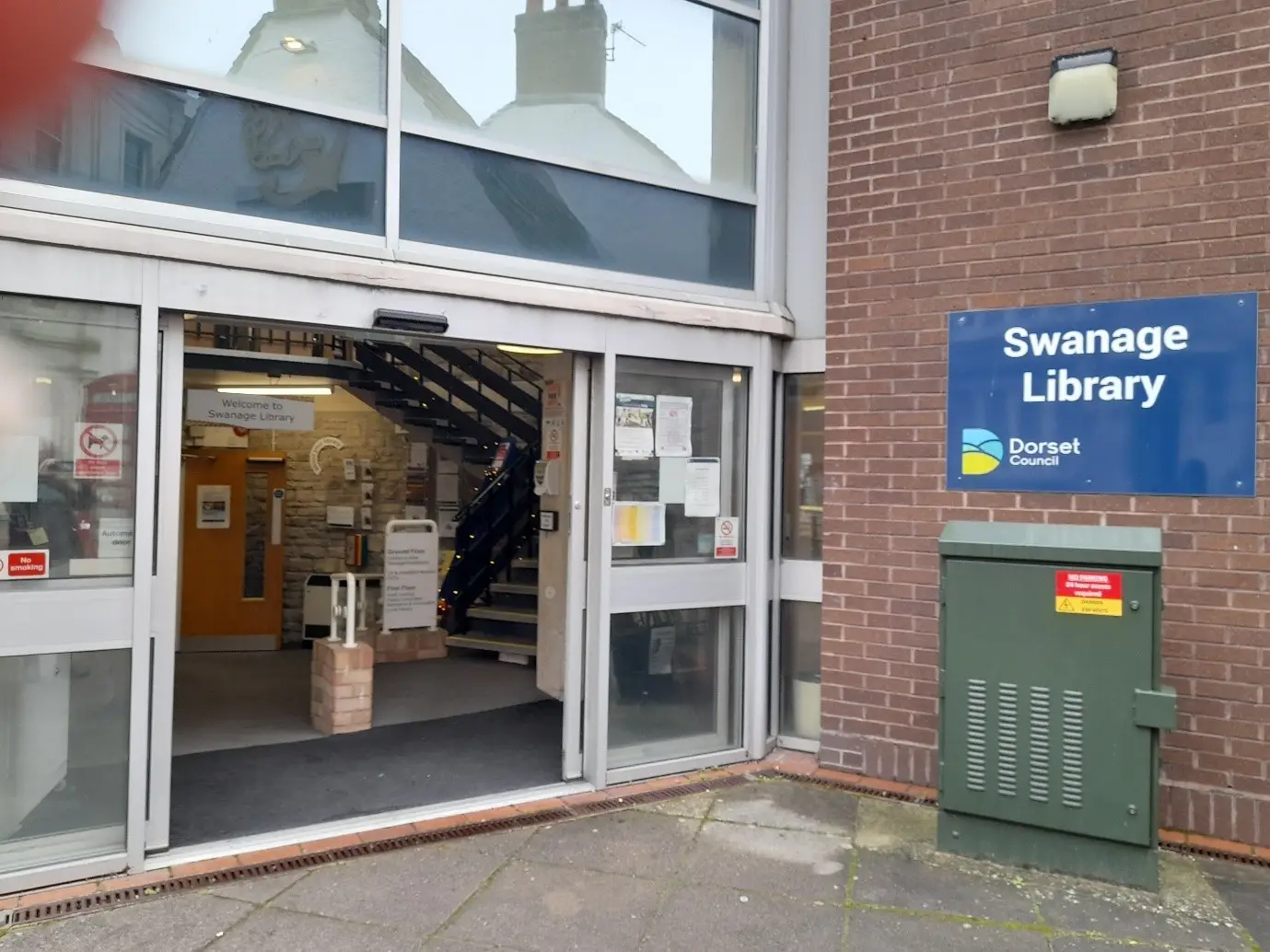 This is a picture of the entrance to Swanage Library with automatic sliding doors.