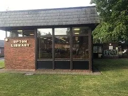 This is a picture of Upton Library it is a brick building with large glass windows.