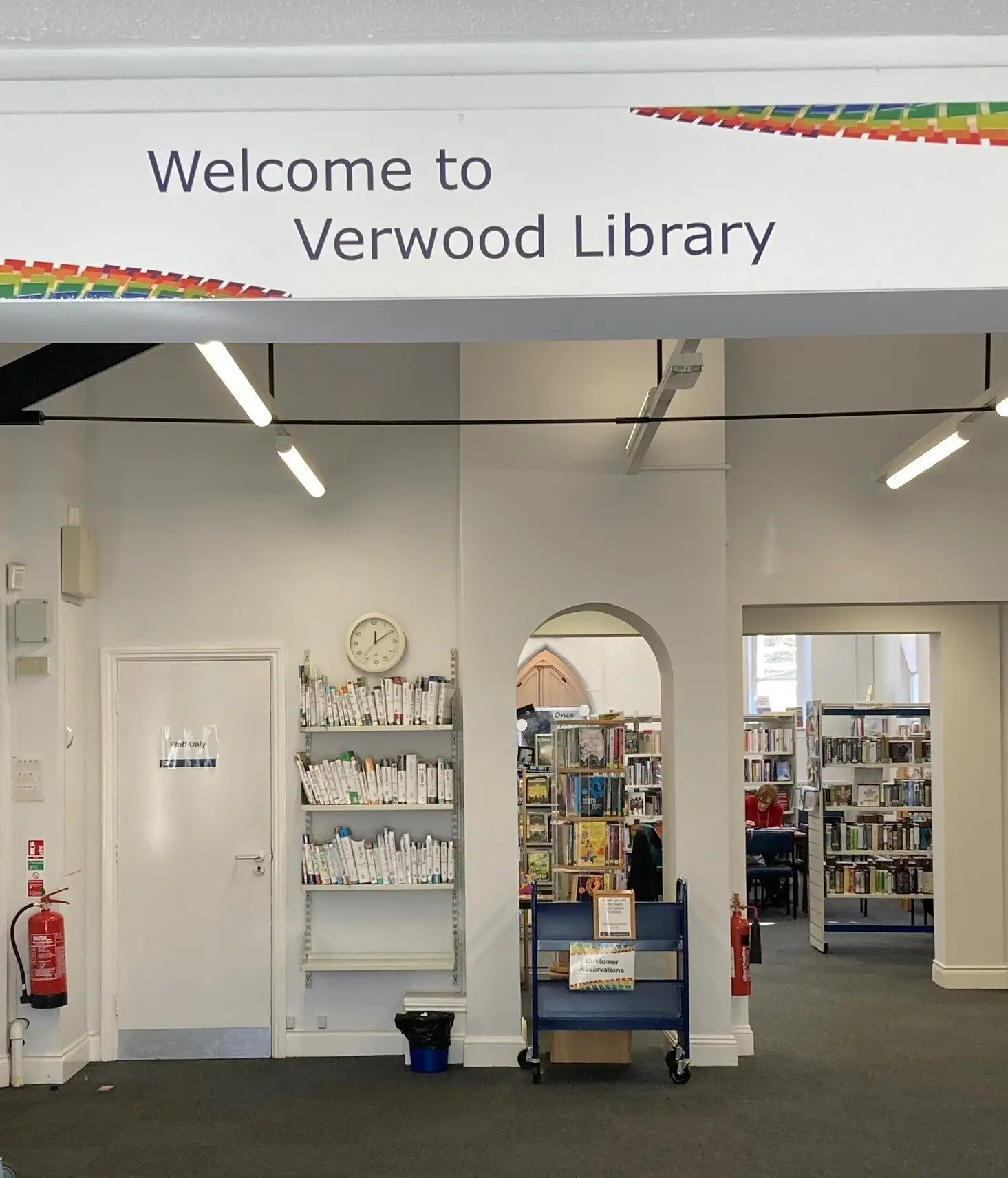 This is a picture of the entrance area once you have come in the front door.  There are rows of shelves full of books in the background.