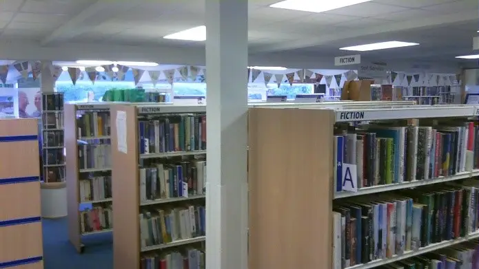 This is a picture of shelves of books in parallel rows.