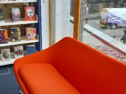 This picture shows a big red sofa that customers can sit and read books on.