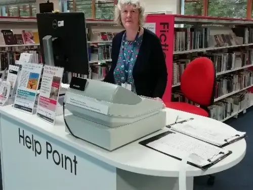 This picture shows a member of staff behind a desk.