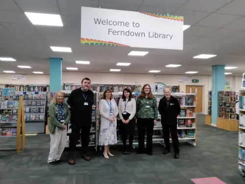 This is an image of six library assistants standing and smiling at the camera.