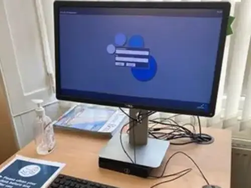 This is an image of a computer screen on a desk with keyboard in front.