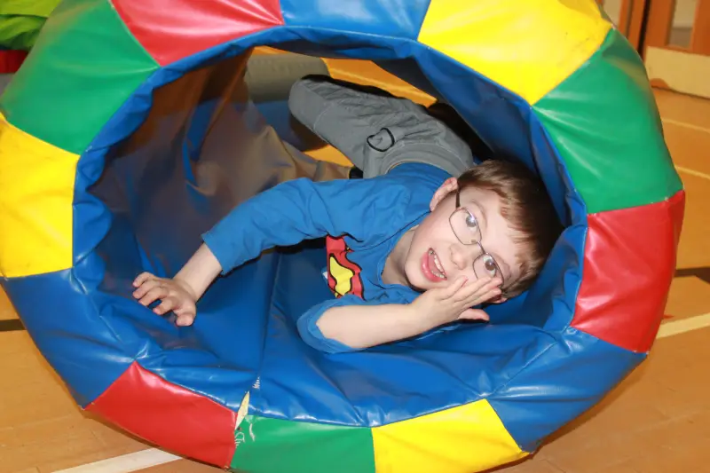 Boy playing in soft play tunnel