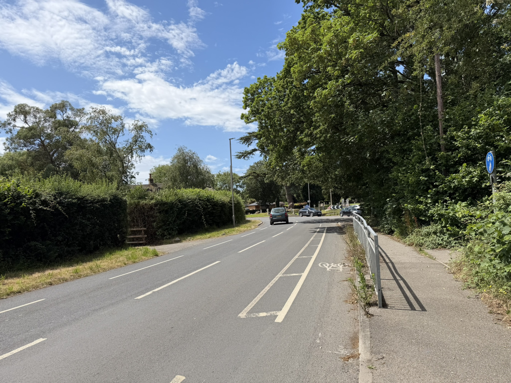 A road with a car pulling away on a bend