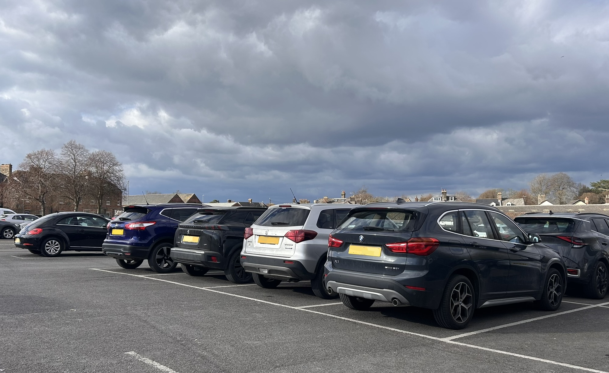 a row of black and silver cars parked in a car park