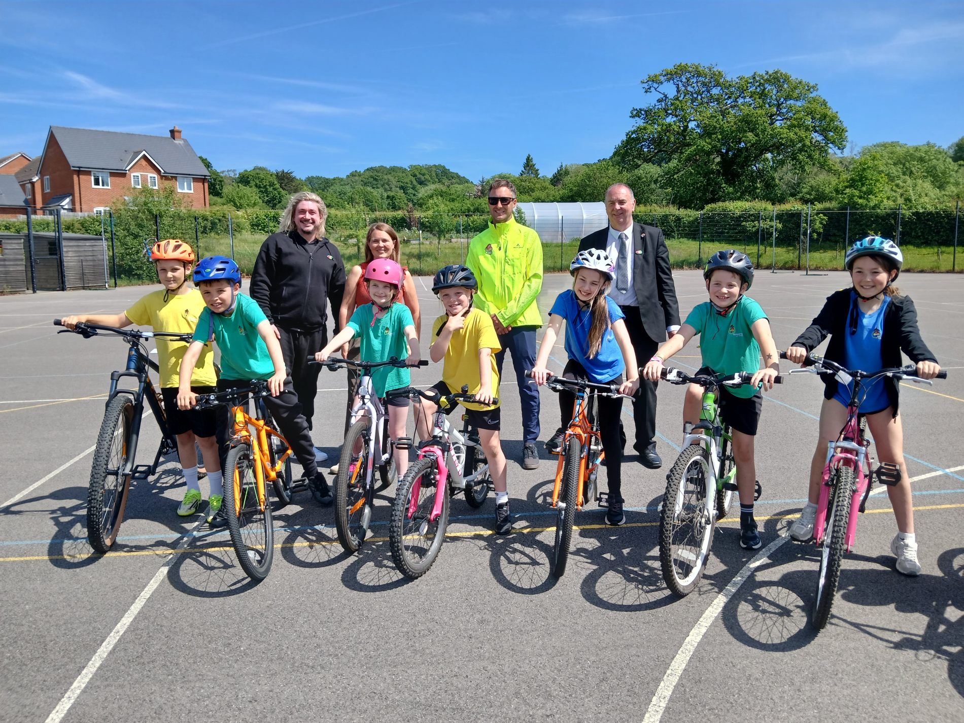 A row of children on bicycles smiling at the camera