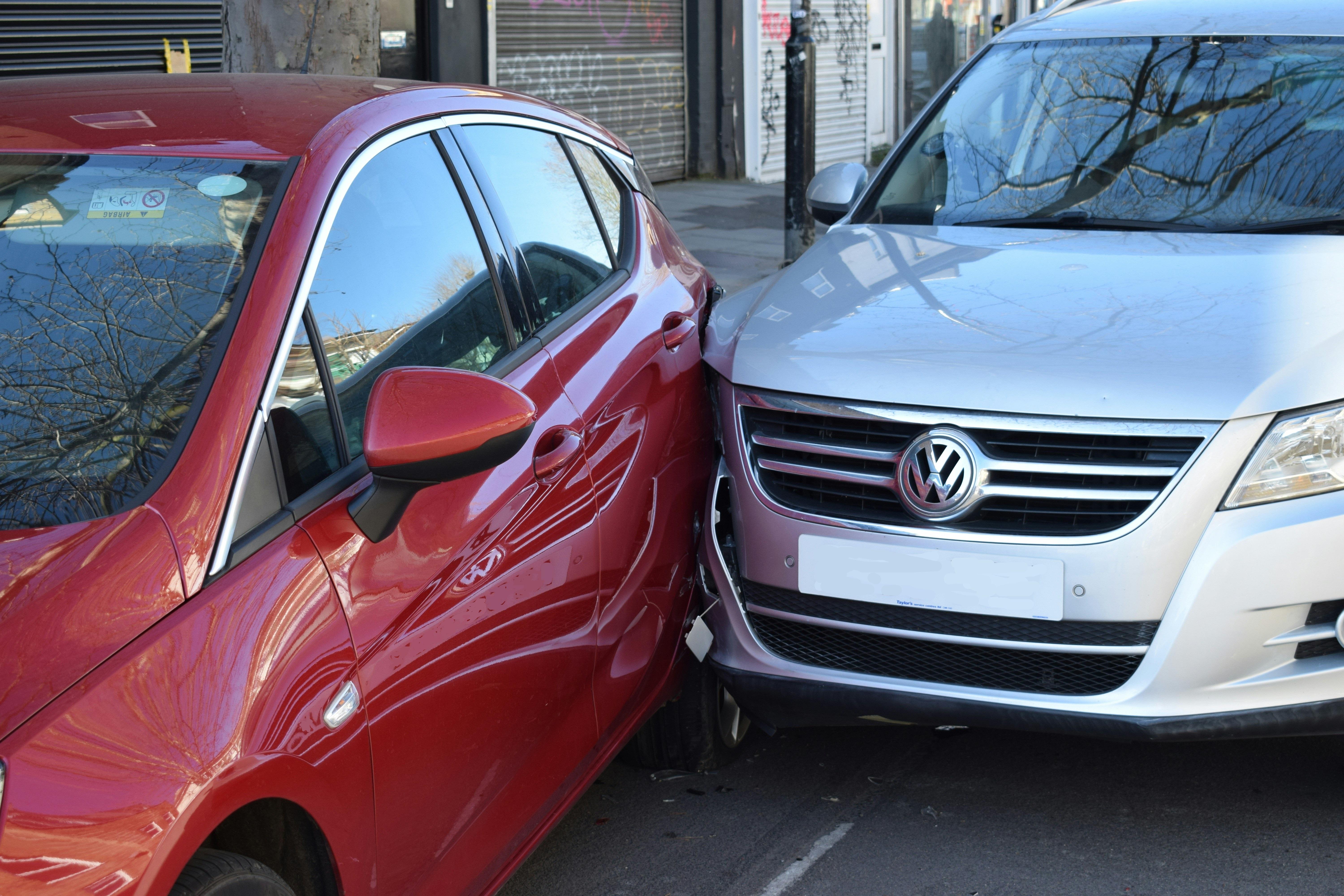 A silver car and red car in a minor collision