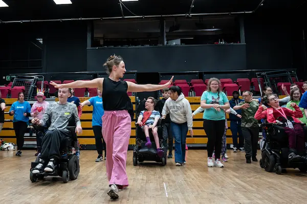 Image of the dance instructor demonstrating the routine in front of a group of participants
