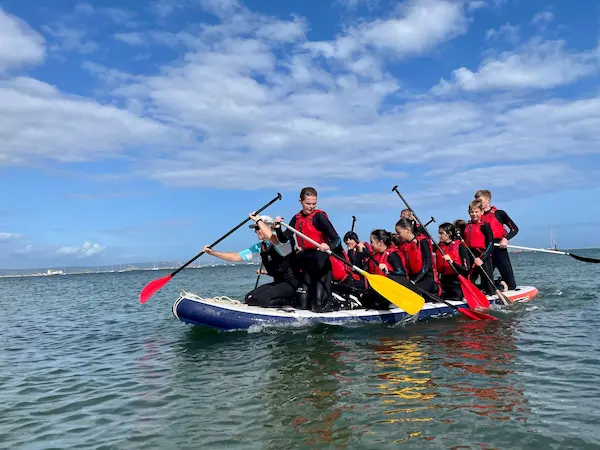 A group of people on a mega stand up paddleboard