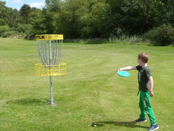 Picture of a boy throwing a frisbee towards a target
