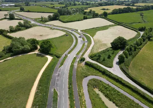 Aerial view of Gillingham’s main street, showing road infrastructure, adjacent green spaces, and surrounding development areas. The image illustrates transport planning aligned with major housing growth and sustainable urban expansion