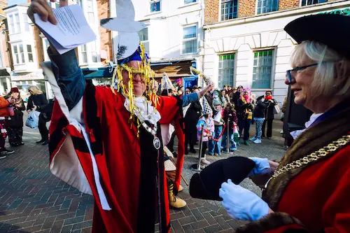 Ceremonial handover event taking place in a town centre with people in civic dress.