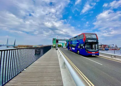 Morebus route 8 travelling across Poole Bridge with Twin Sails Bridge in the background framed by picturesque sky.