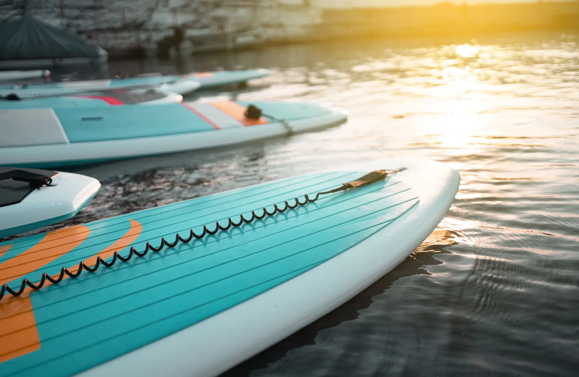 Close up of a paddle board with the sun reflecting on water