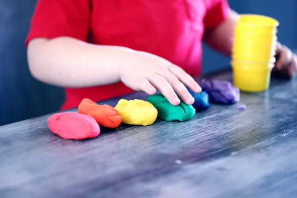 A child playing with different coloured play dough