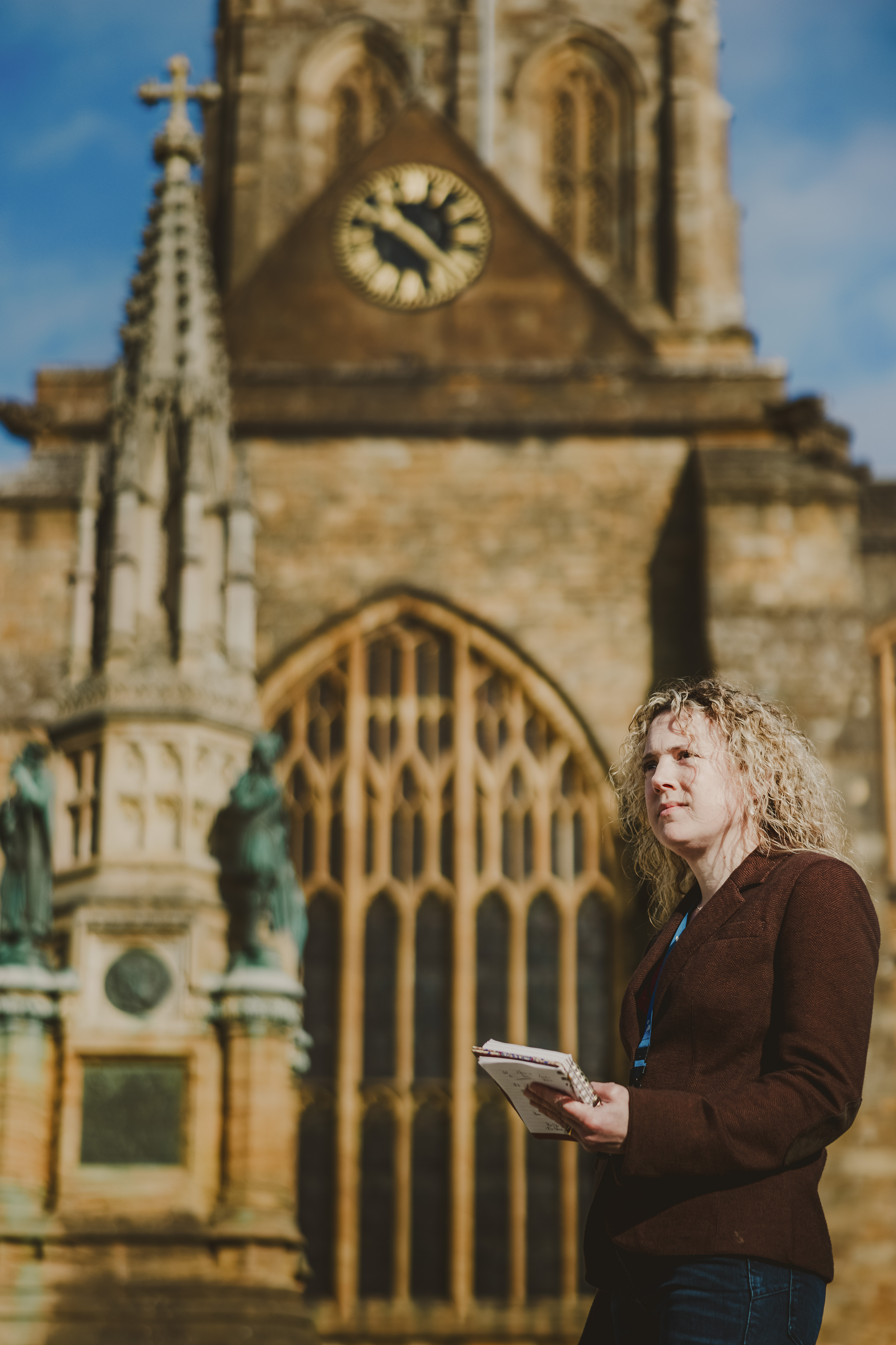 Person stood with a notepad in front of a church