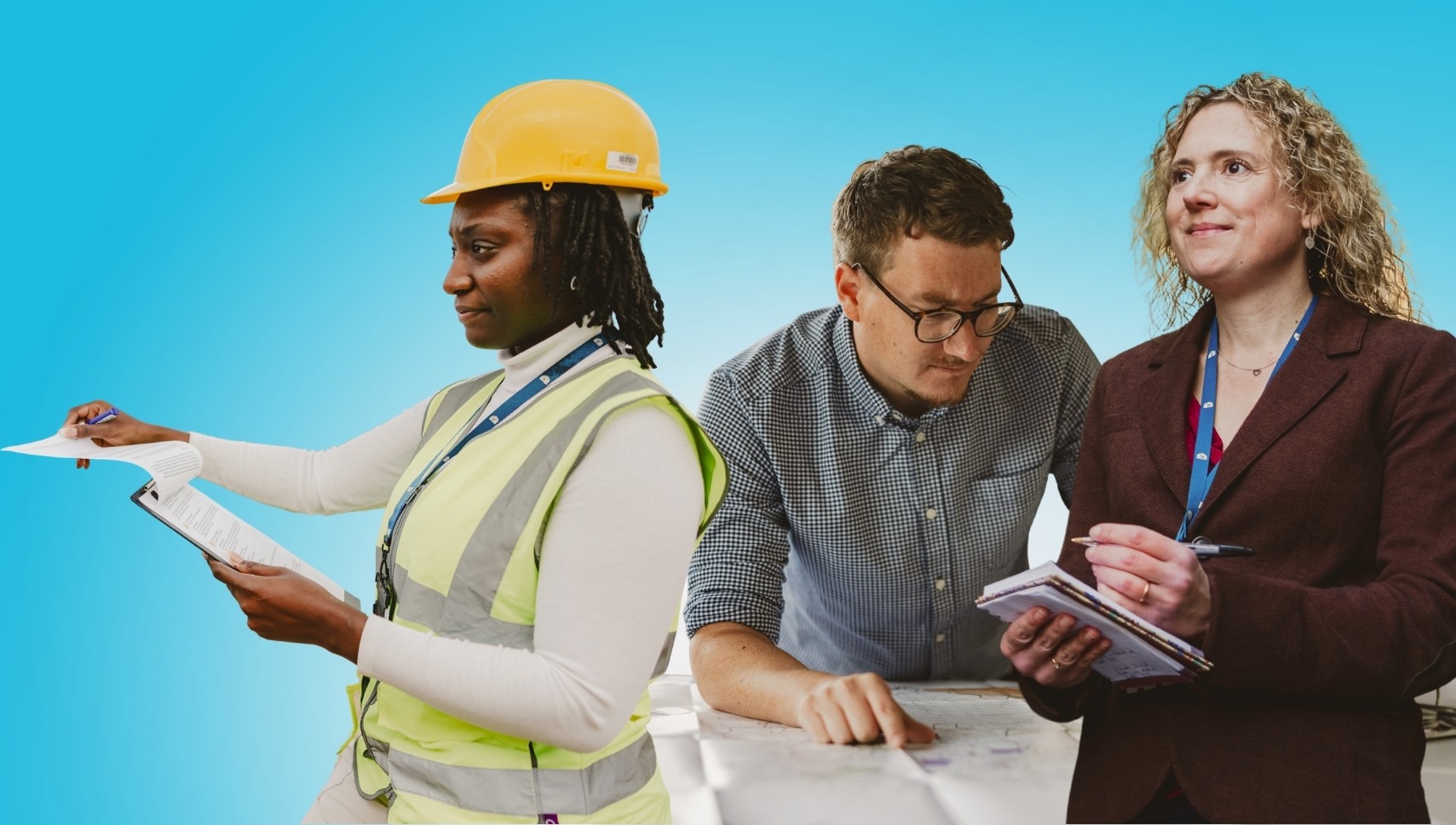Three colleagues holding books and a laptop with a bright blue background