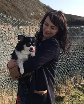 A photo of Tania Carter holding a small black and white dog.