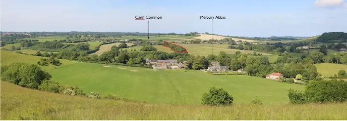 Viewpoint 10: View looking north from the junction of the public bridleway and the public footpath within the Open Access Land between Melbury Hill and Compton Down The canopies of the trees within the site boundary are visible in the middle of the view (indicated with a red outline). There will be a perceptible reduction in the mass and density of the woodland.