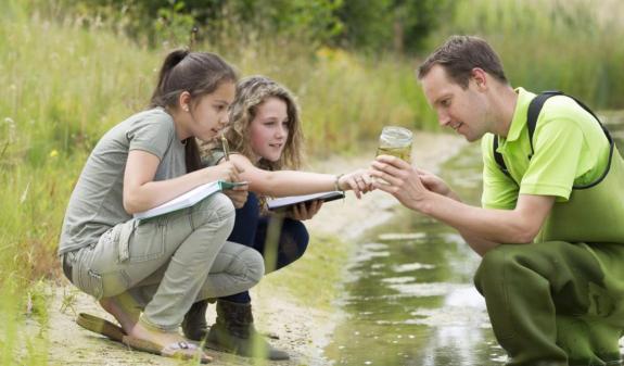 a man and two children testing water quality