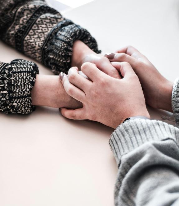 Two people holding hands in a caring manner