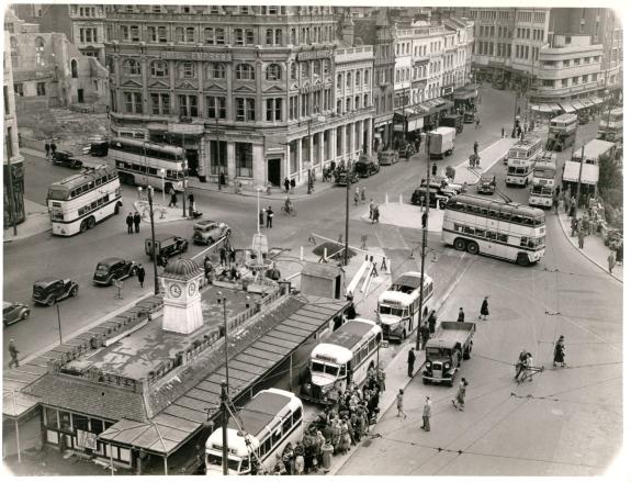 An old black and white photo of Yellow Buses in the centre of Bournemouth - what is now the pedestrianised square. The view is from an upper level of Bobby's department store.