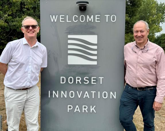 Two men stood next to a sign that says welcome to the Dorset Innovation Park