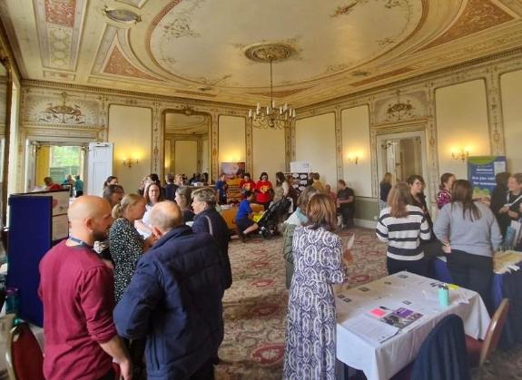 People standing talking with each at an event in an ornate room